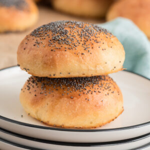Two buns stacked on a white plate.
