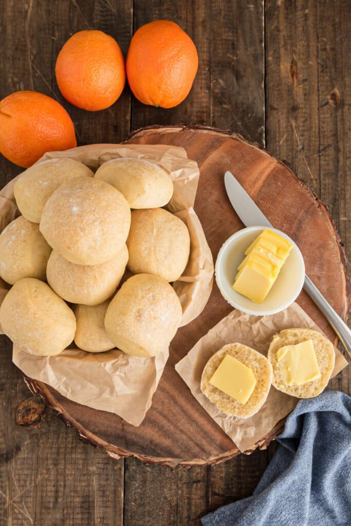 Buns in a basket and one cut in half with butter.