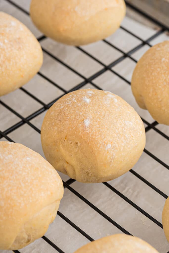 Orange savory buns on a wire rack.