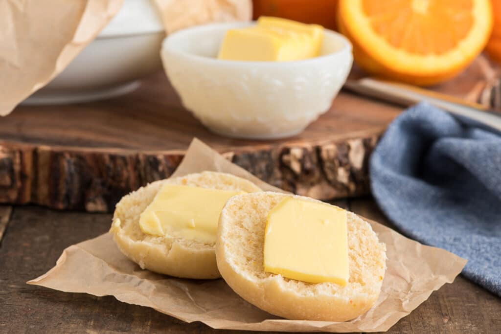 A bun cut in half with butter.