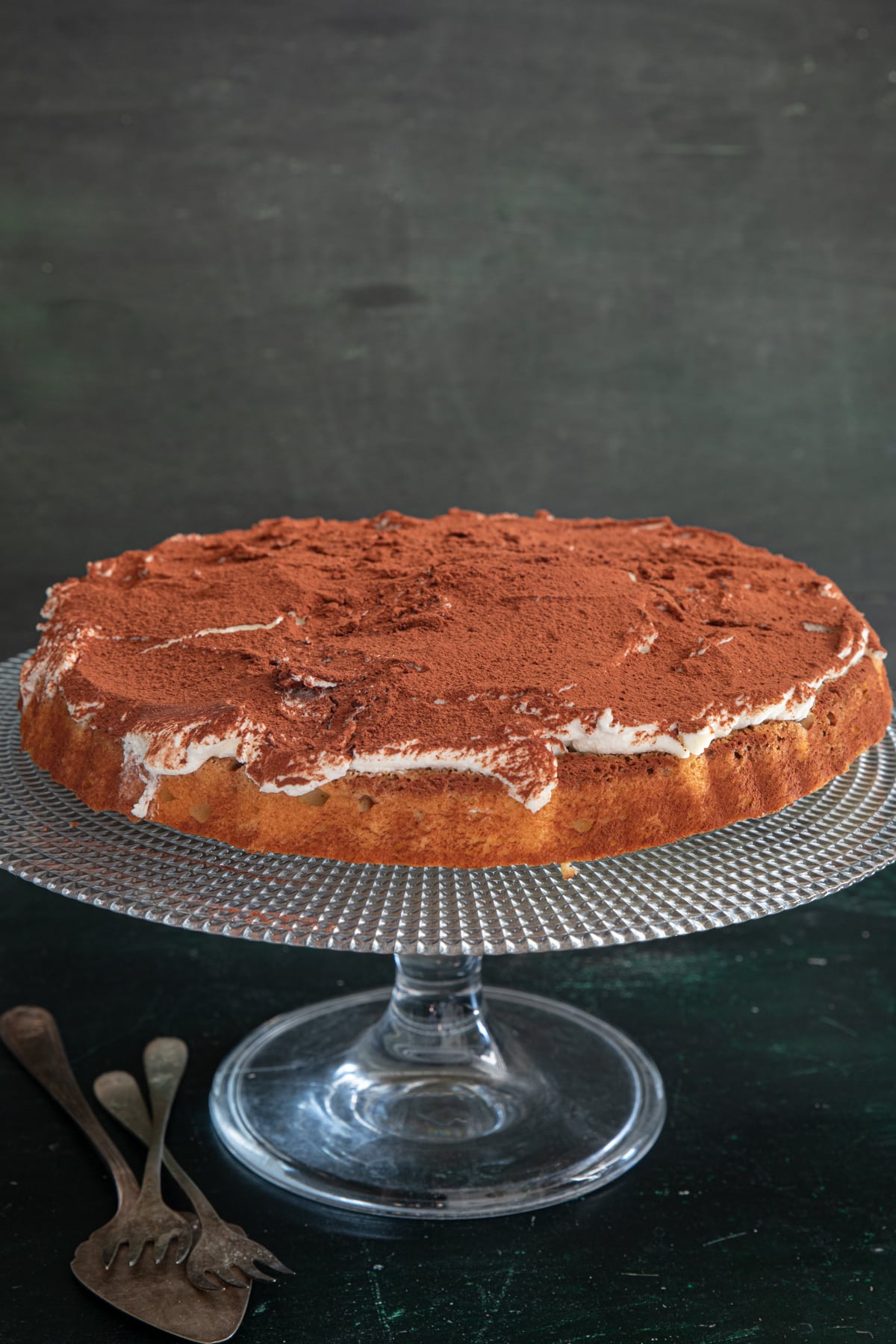 Tiramisu crostata on a glass cake plate.