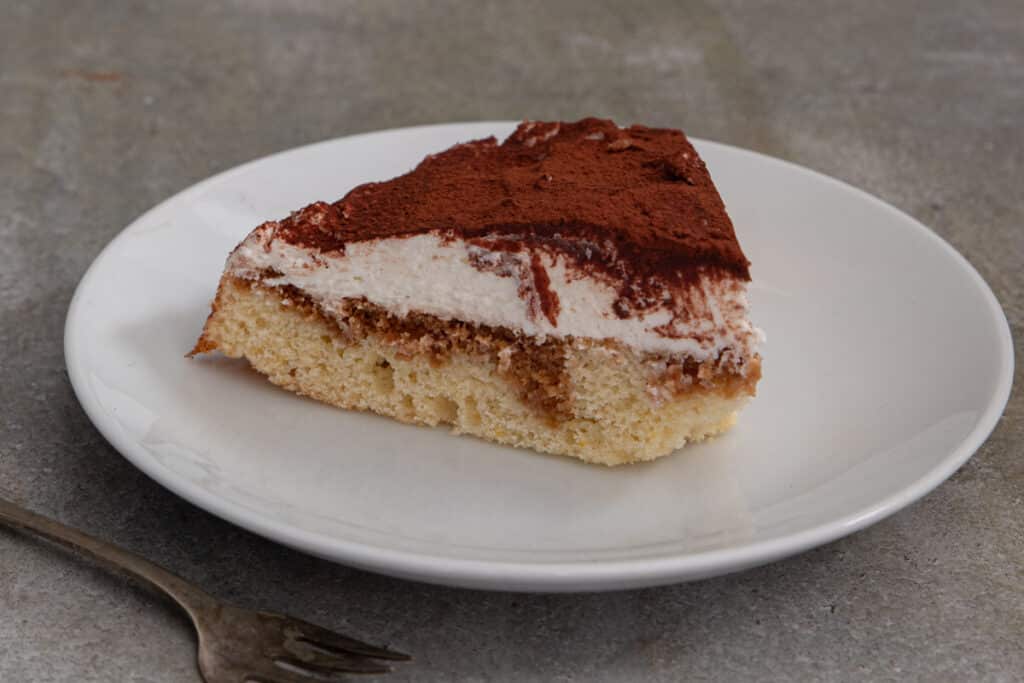 A slice of tiramisu crostata on a white plate.